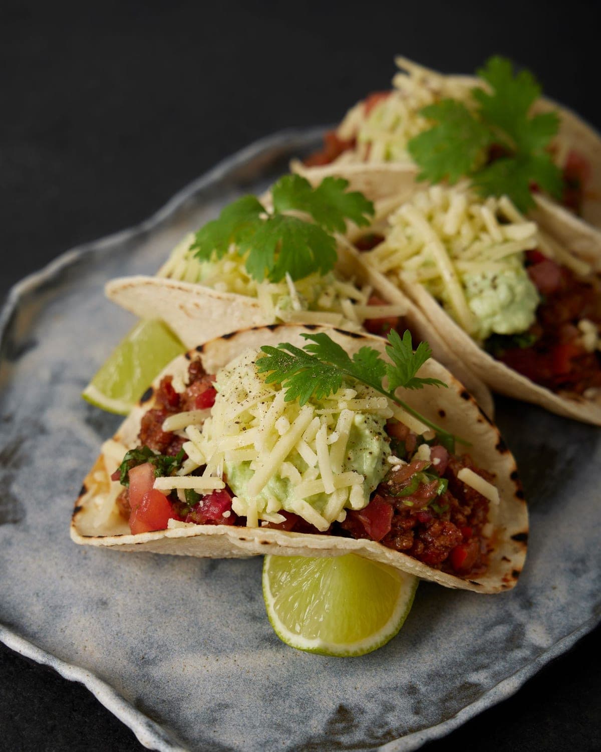 Beef tacos topped with cheese and salsa